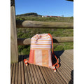 A mochila Btbox aberta, exibindo o grande compartimento principal e a etiqueta interna para identificação do nome.