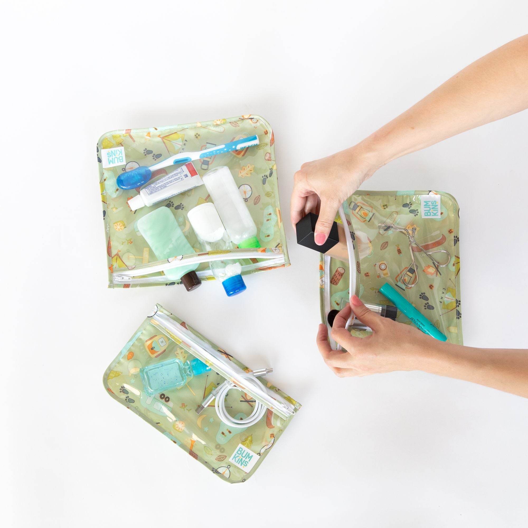 Bolsas organizadoras impermeáveis Bumkins com produtos de higiene, maquilhagem e cabos eletrónicos