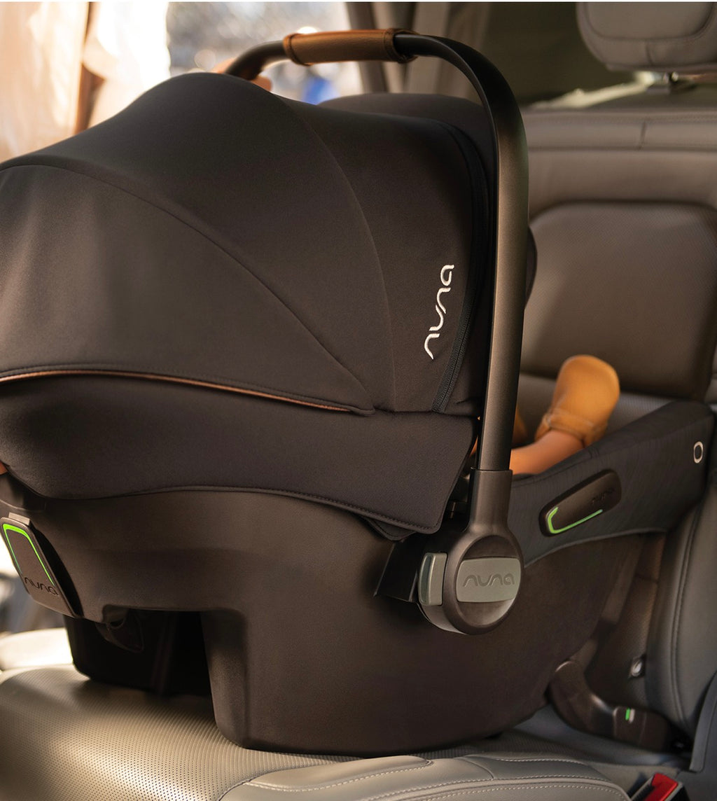 Bebé confortável na cadeira Nuna Pipa Urbn, com a capota Dream drape™ estendida, oferecendo máxima privacidade e proteção solar UPF 50+.