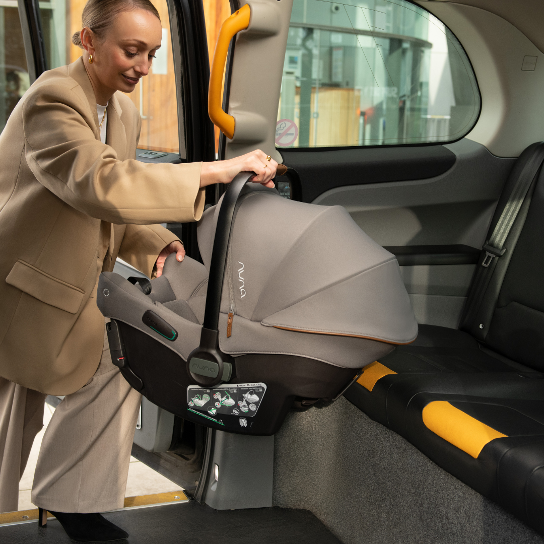 Cadeira auto ovo Nuna Pipa Urbn ultraleve (3,3kg) em cinzento escuro, vista frontal, destacando o design moderno e a alça de transporte em couro sintético.