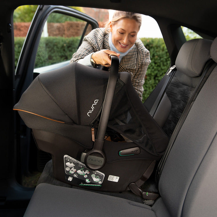 A cadeira auto Nuna Pipa Urbn em destaque, com as especificações visíveis: ultraleve, ISOFIX integrado e certificação ECE R129/03.