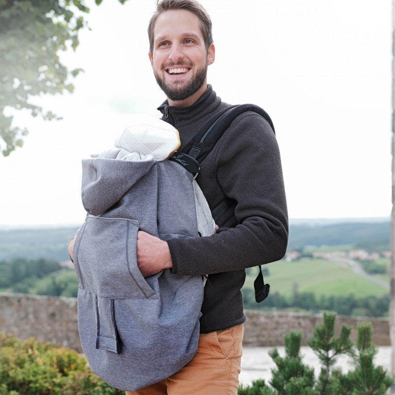 Pai a usar a Capa Babywearing Neobulle cinzenta com bebé num porta-bebés