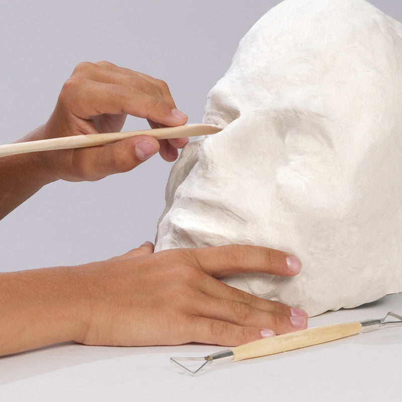 Trabalho detalhado de escultura com pasta de modelar branca e ferramentas