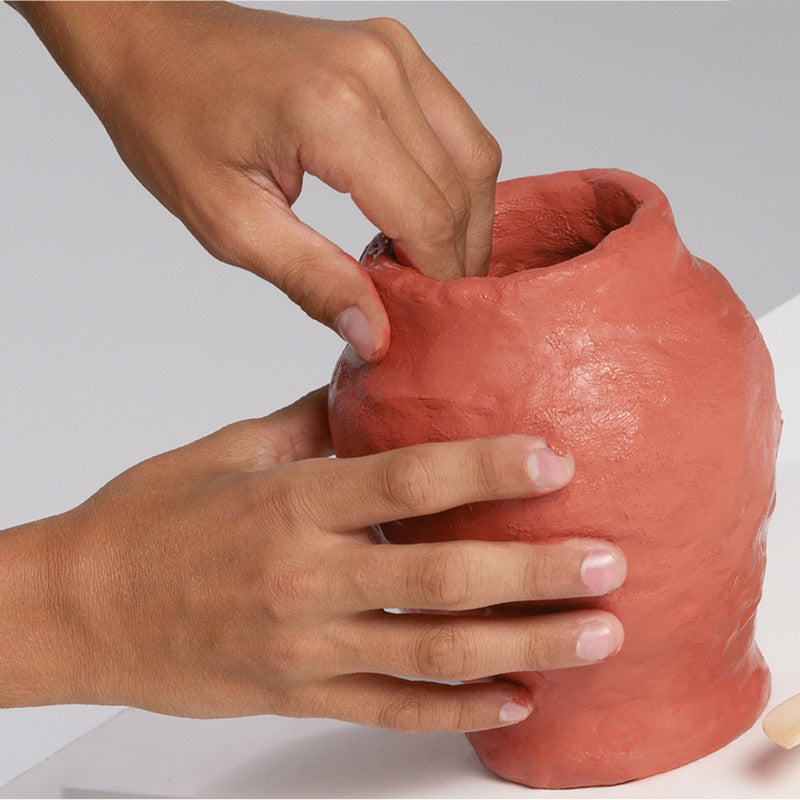 Mãos a moldar um vaso artesanal com pasta terracota Carioca Déco