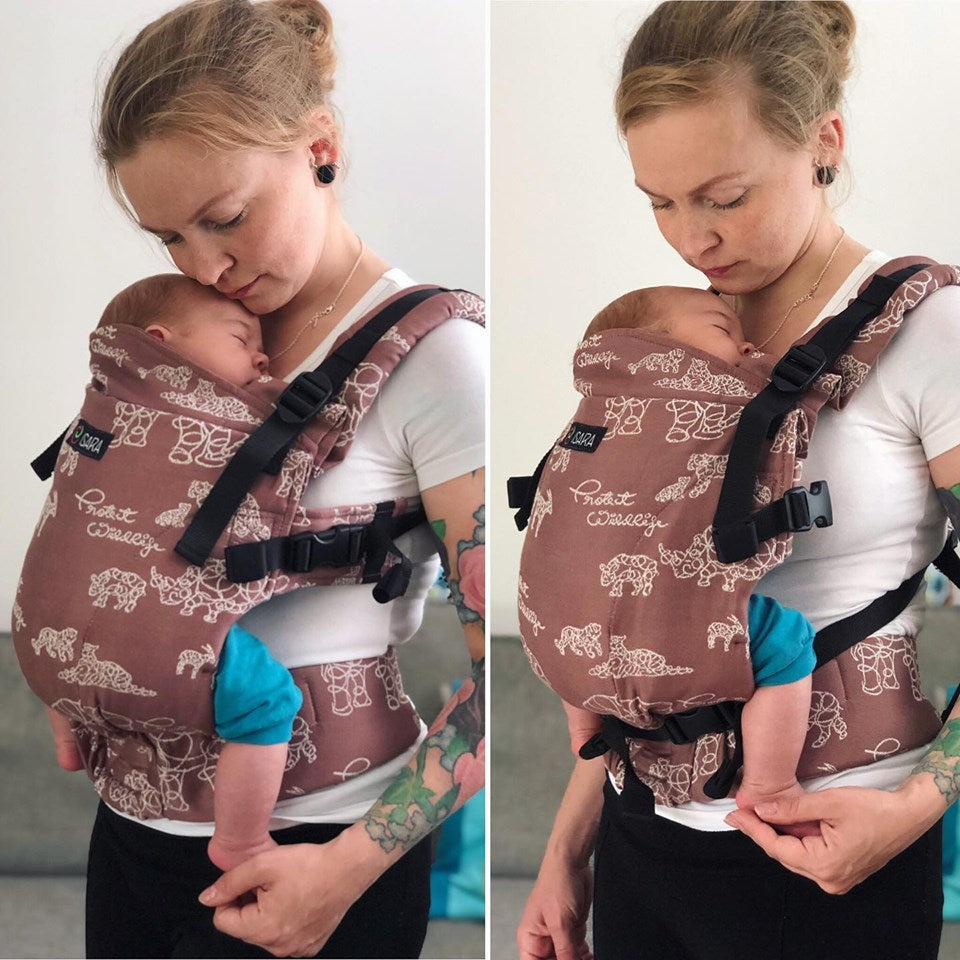 Mulher utilizando uma mochila ergonómica ISARA com um bebé, destacando o uso do cinto de ajuste infantil. A imagem mostra a segurança e o conforto proporcionados pelo cinto.