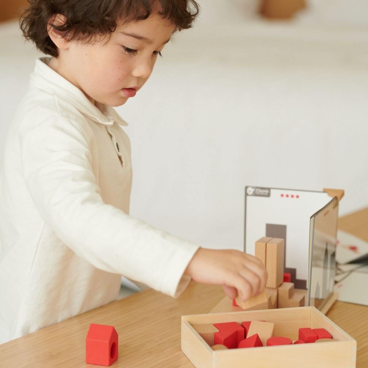 Criança brincando com os Classic World Blocos de Construção com Sombras, aprendendo sobre formas e projeção.