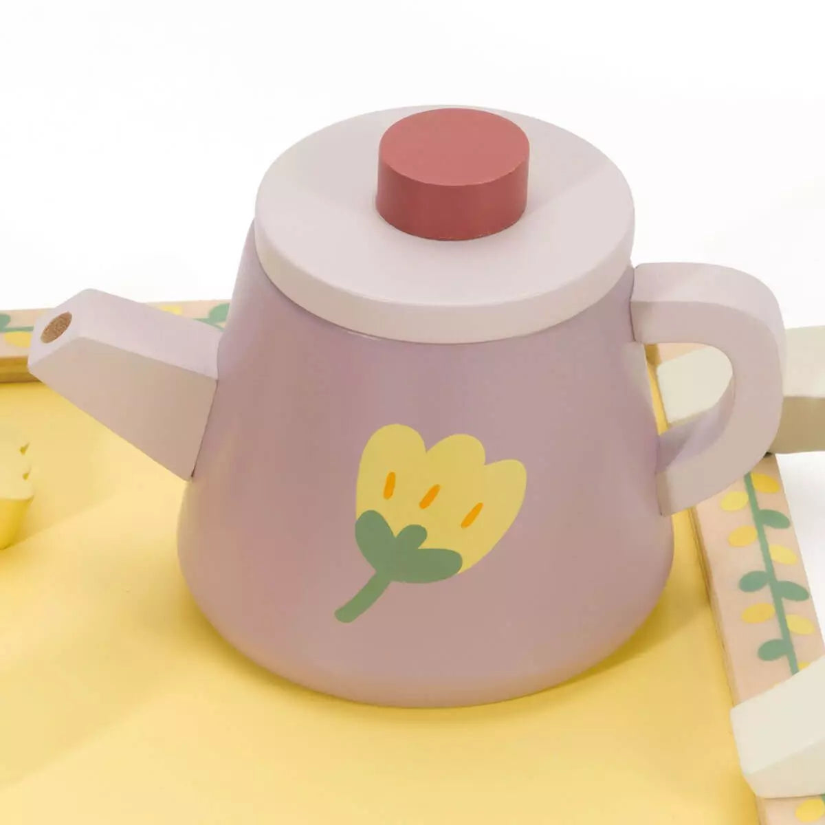 Detalhe do bule do Classic World Conjunto para chá Grace, com uma flor amarela pintada e cores suaves.