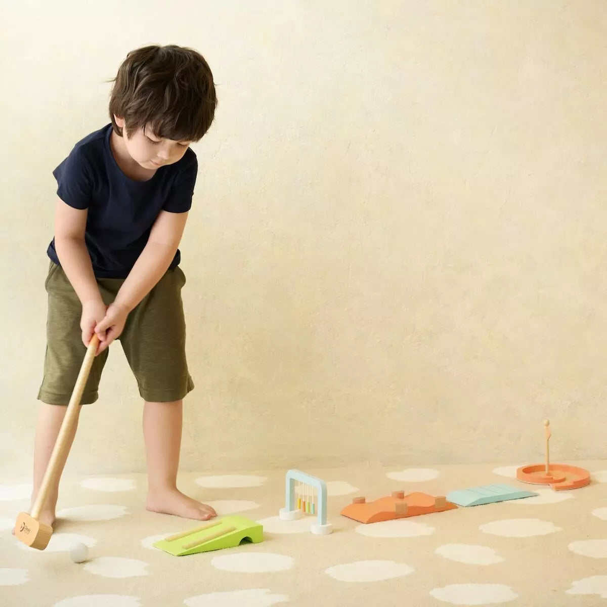 Criança a jogar Classic World Jogo Minigolf, demonstrando o uso e a escala do brinquedo.