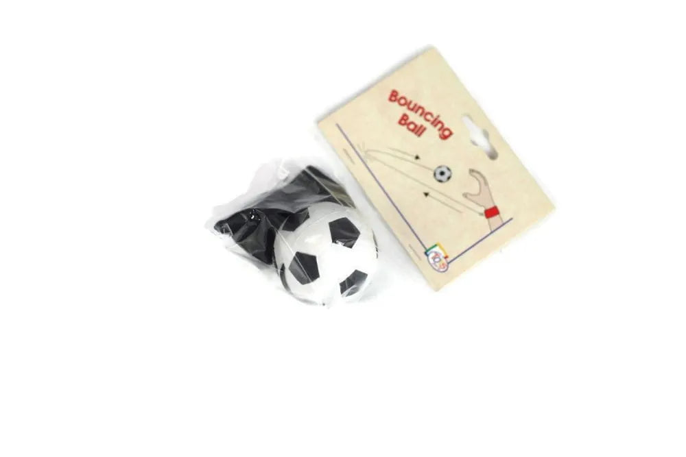 Criança a brincar com o jogo Goki Vai e Vem, demonstrando o movimento de lançamento e apanhar a bola.