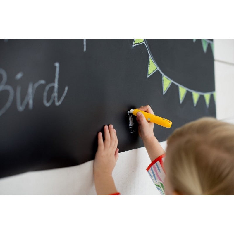 Criança a desenhar num quadro negro com o suporte amarelo Jaq Jaq Bird.