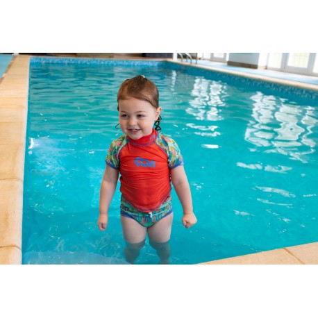 Criança a brincar na piscina com camisola de proteção solar