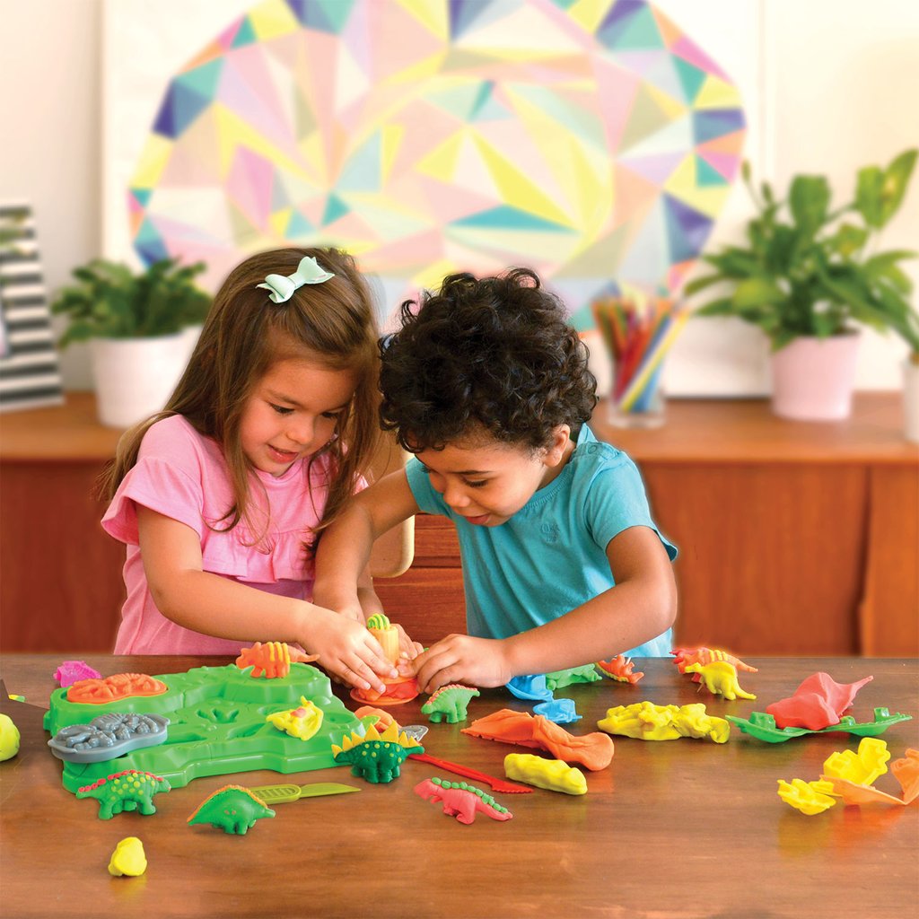 Crianças felizes a brincar com o kit de plasticina Ilha dos Dinossauros.