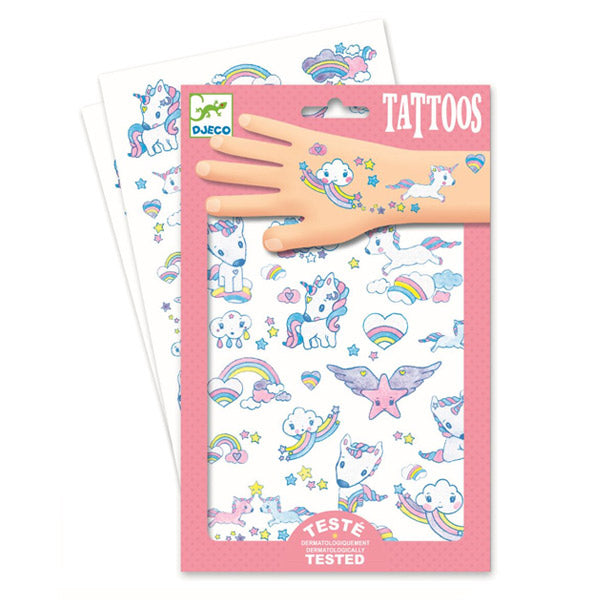 Embalagem das tatuagens Djeco 50 Tatuagens com glitter Unicórnios, mostrando duas folhas de decalques com ilustrações de unicórnios, arcos-íris e estrelas, com uma mão a exibir tatuagens aplicadas.