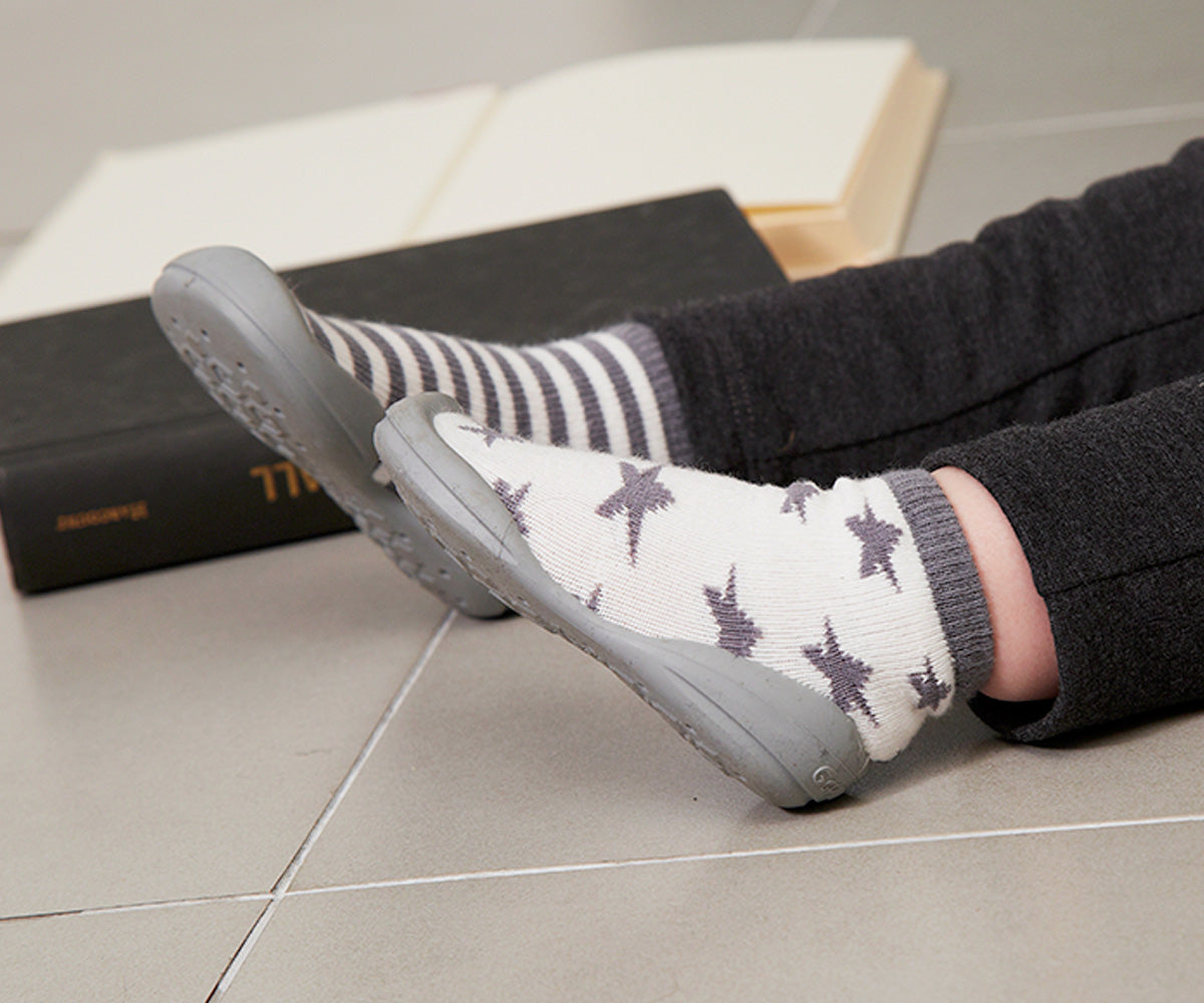 Detalhe dos pés de um bebé com sapatos Banannas Star e Stripes.