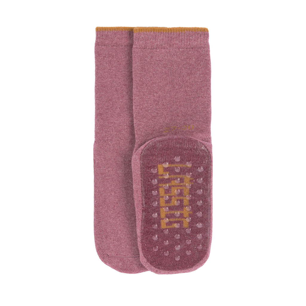 Detalhe da sola de silicone das meias rosa Lassig.