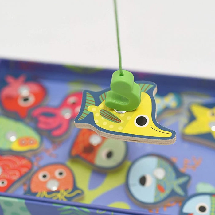 Detalhe de um peixe amarelo magnético do jogo Djeco Fishing Colour a ser pescado pela cana.