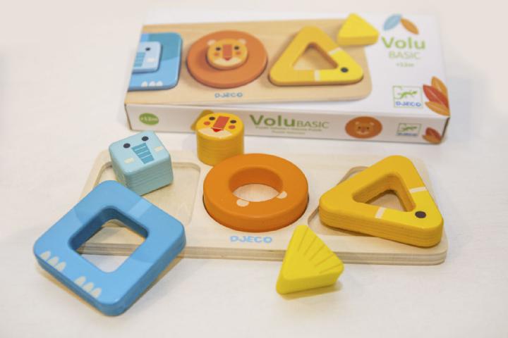 Puzzle Djeco VoluBasic com formas de animais (elefante, leão) e geométricas (quadrado, círculo, triângulo) fora da base de madeira.
