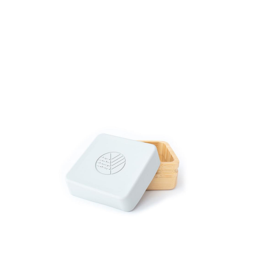 Os dois recipientes (rosa e cinza) lado a lado, destacando o design minimalista e ecológico dos porta-snacks de bambu.