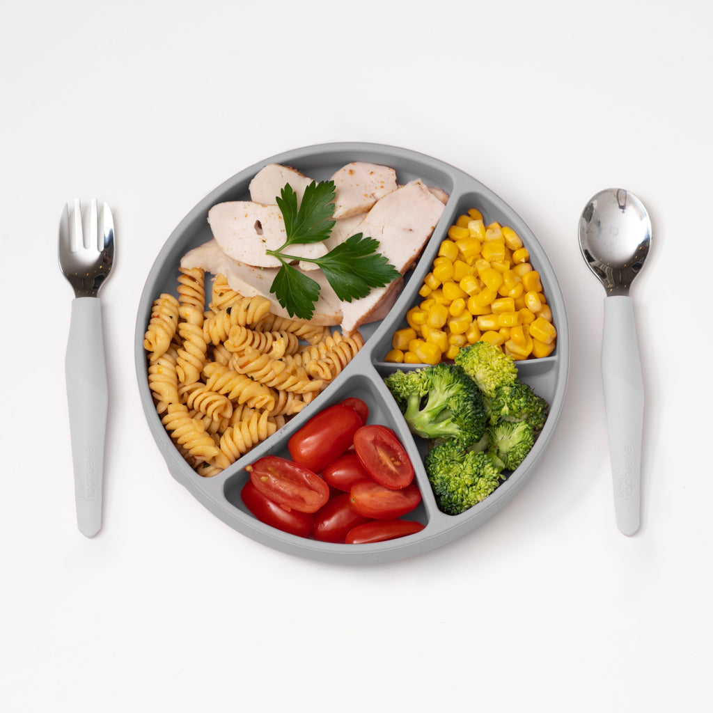 Prato de silicone com ventosa Everyday Baby colocado num tabuleiro de cadeira alta com alimentos variados.