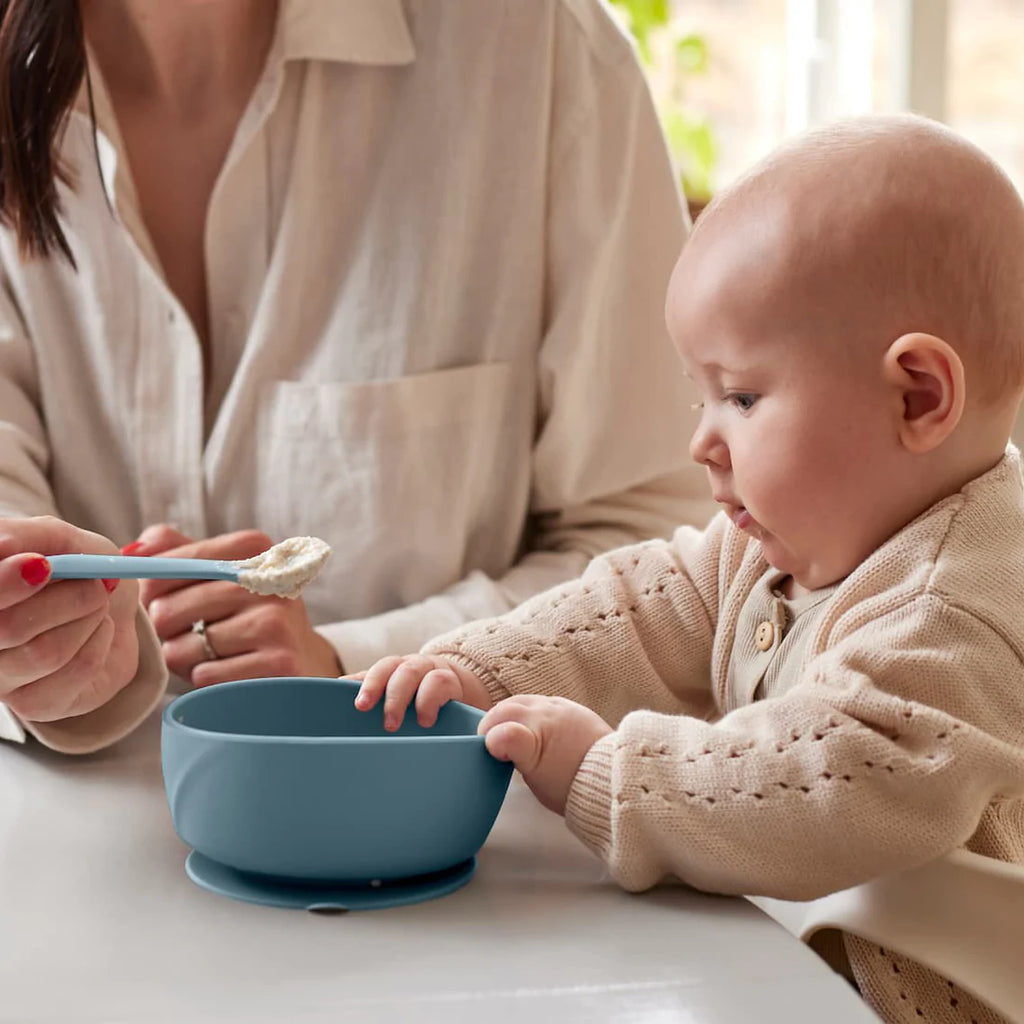 Taça/tigela de silicone Everyday Baby azul-claro, com ventosa forte, cheia de papa de bebé, ideal para introdução alimentar.