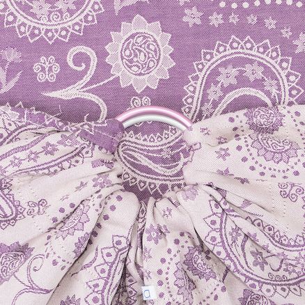 Um sling de argolas Fidella Persian Paisley Orchid em destaque. O tecido apresenta um elegante padrão paisley em tons de roxo e lilás. As argolas, que são robustas e metálicas, estão centralmente visíveis, segurando o tecido de maneira firme. O design detalhado do padrão paisley é visível tanto no fundo roxo quanto na parte principal do sling, que é de um tom mais claro de lilás.