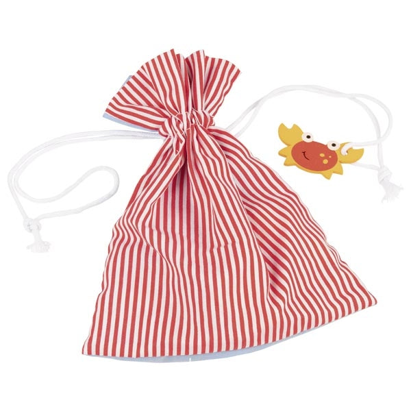 Saco de tecido com riscas vermelhas e brancas, fechado com um cordão branco, com uma peça de caranguejo de madeira pendurada.
