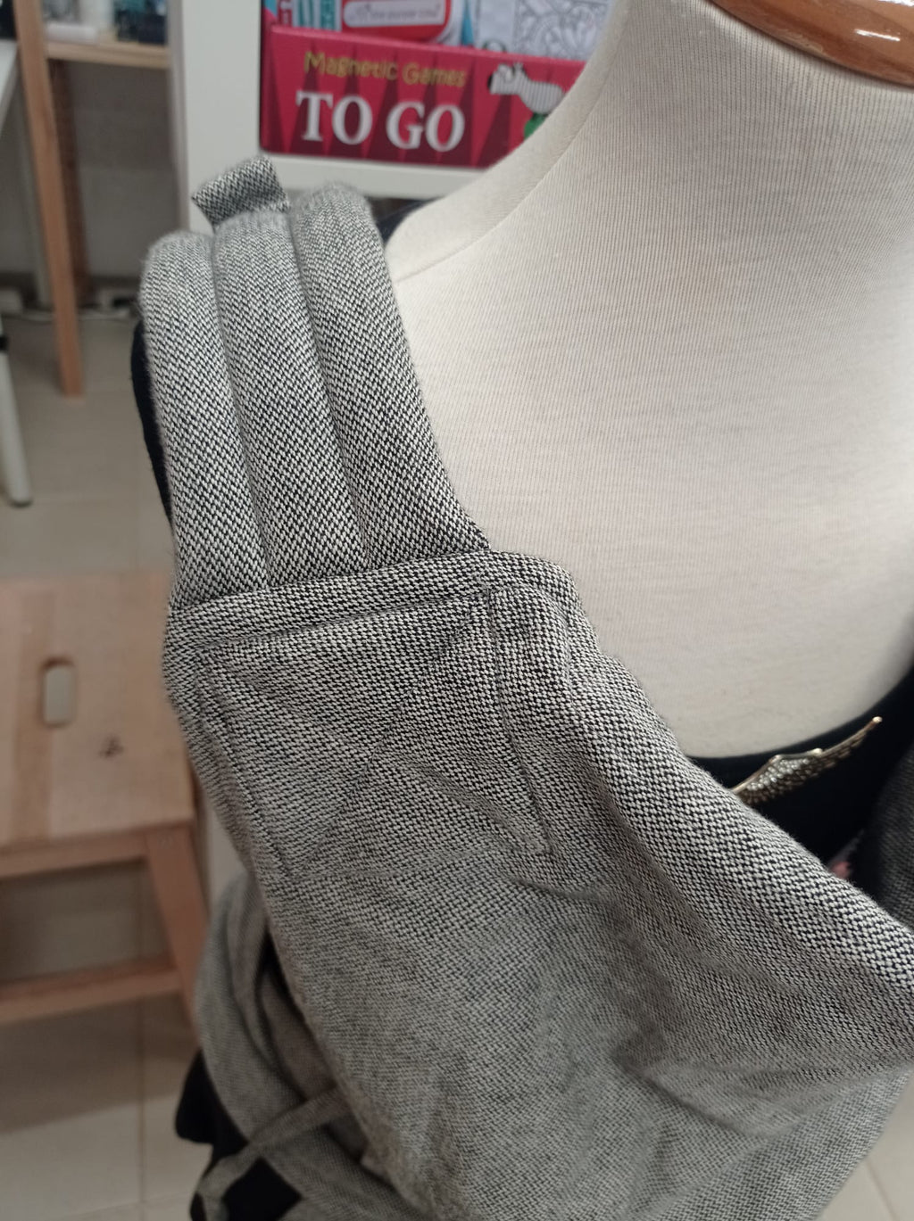 Detalhe do porta-bebés cinzento em tecido de sarja, mostrando a qualidade e o design do produto Gotu para aluguer.