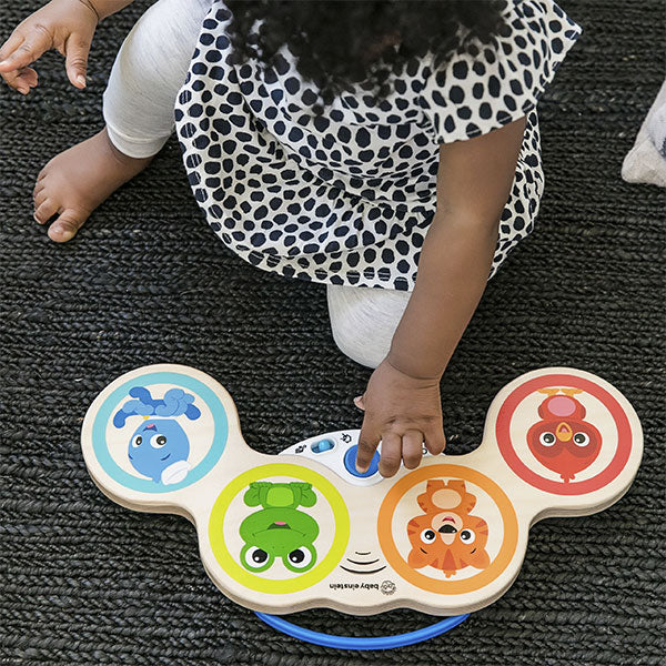 Bebé a tocar nos Tambores Mágicos Hape Baby Einstein, explorando os diferentes sons e ritmos com as mãos.