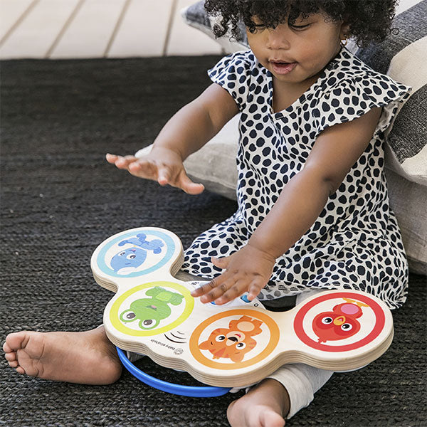 Criança a interagir com os Tambores Mágicos Hape Baby Einstein, demonstrando a facilidade de uso e o apelo divertido do brinquedo.