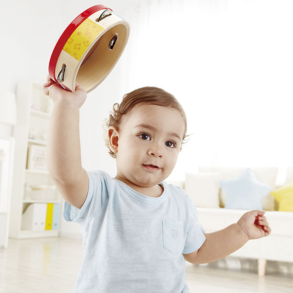 Imagem de embalagem da Pandeireta Tap-along da Hape, mostrando o produto e informações de idade recomendada (12m+).