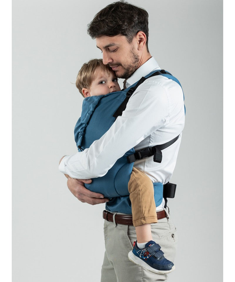 Homem ajustando a Mochila Isara Toddler Preschooler BLUESTONE enquanto carrega bebé.