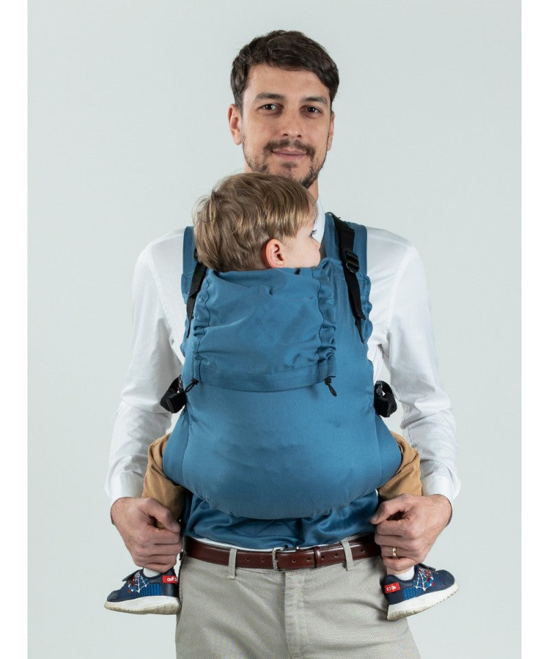 Homem ajustando a Mochila Isara Toddler Preschooler BLUESTONE na posição frontal.