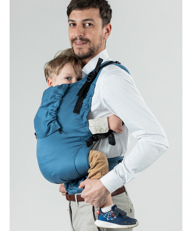 Homem usando a Mochila Isara Toddler Preschooler BLUESTONE com bebé na posição frontal.