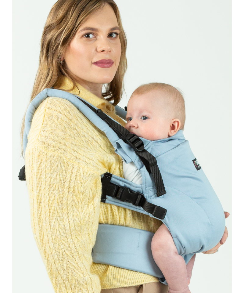 Imagem de uma mãe a usar a Mochila ISARA The ONE Ajustável AZZURRO com o bebé de lado, mostrando a ajustabilidade e conforto do porta-bebés.