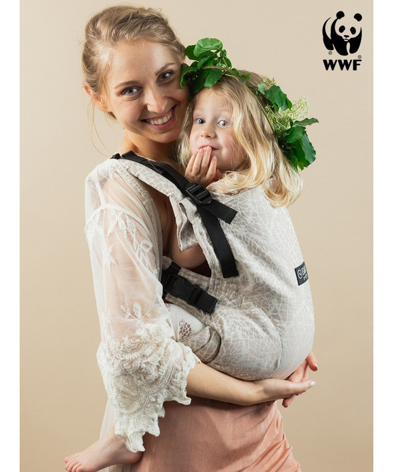 Mulher a usar a Mochila ISARA The ONE Ajustável MAJESTIC IVORY FOREST com um bebé à frente, ambos sorridentes.