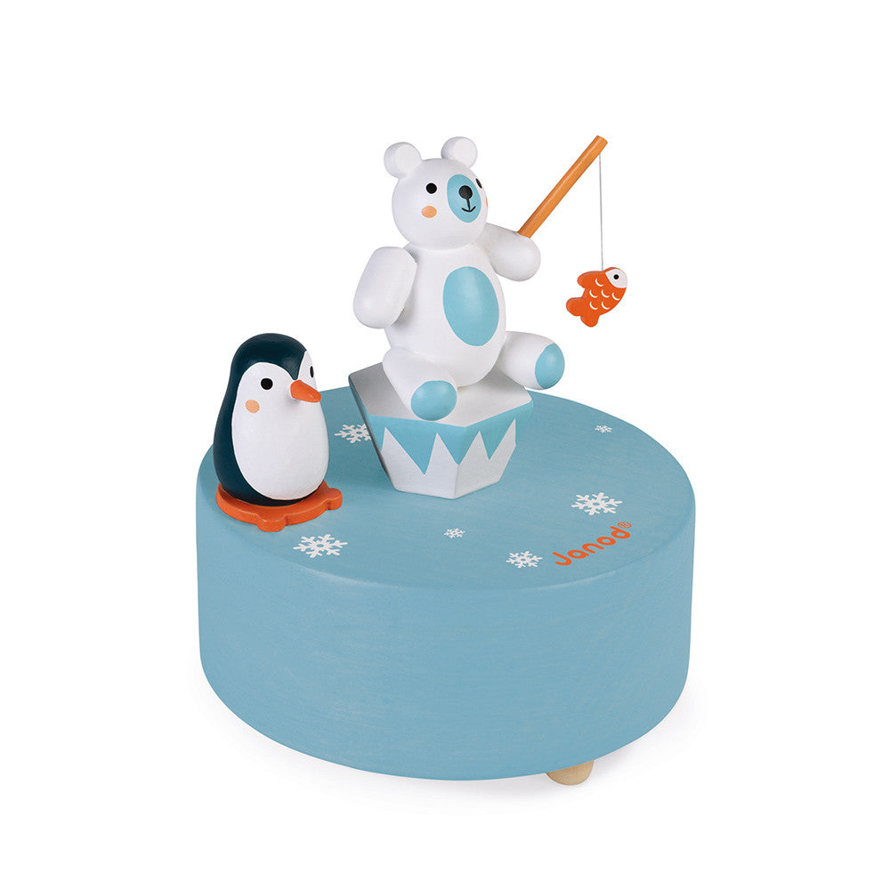 Caixa musical Janod Polar em madeira, vista frontal, mostrando o urso polar e o pinguim magnéticos a rodar.