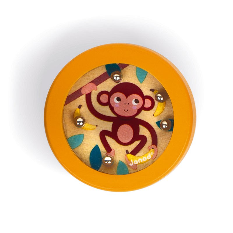 Detalhe do mini jogo da paciência Janod com tema de macaco laranja e bananas, mostrando as 5 bolas de metal no tabuleiro de madeira.