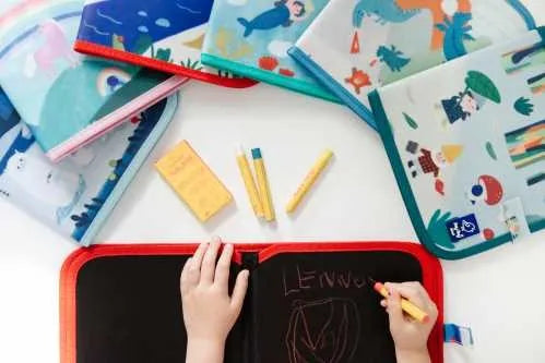 Criança a desenhar um T-Rex no Livro Ardósia Jaq Jaq Bird, demonstrando a facilidade de uso e diversão.