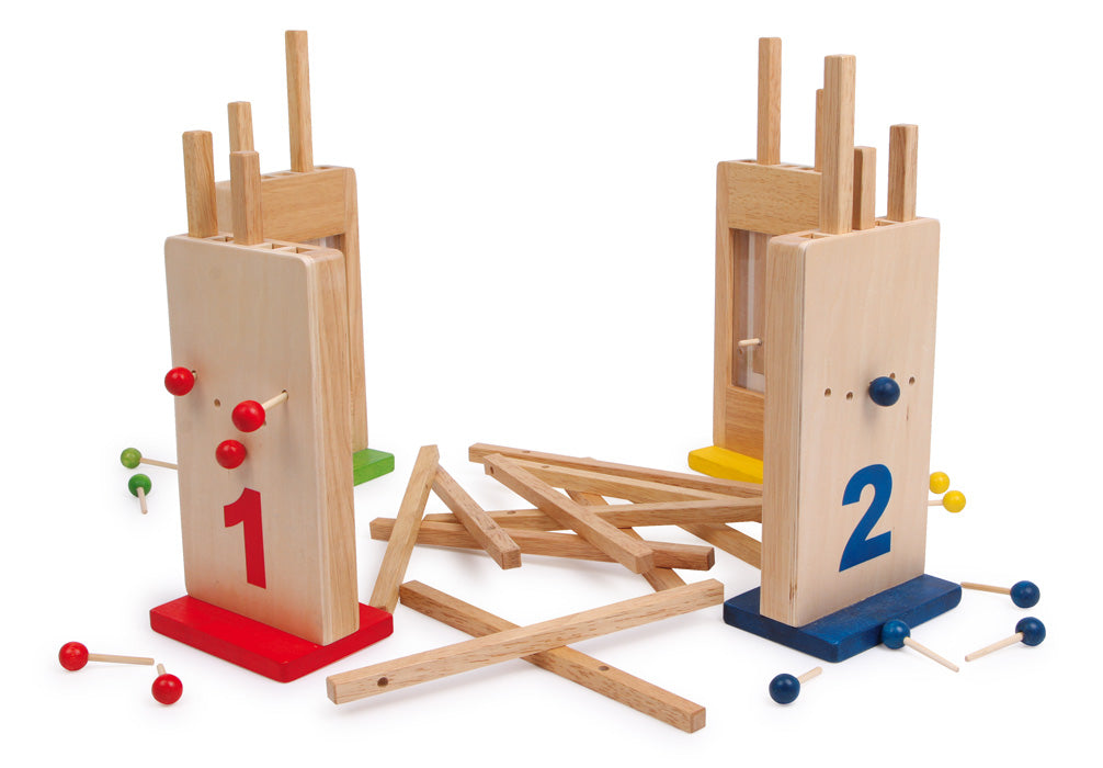 Jogo Buracos Traquinas da small foot em ação, com duas consolas e palitos espalhados na mesa, mostrando o dinamismo do jogo.