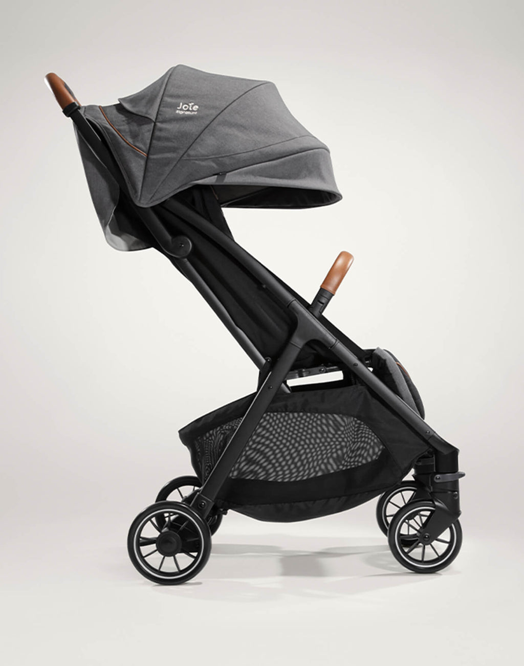 Criança sentada confortavelmente no carrinho Joie Parcel Signature, com apoio de pernas ajustado e cinto de 5 pontos.