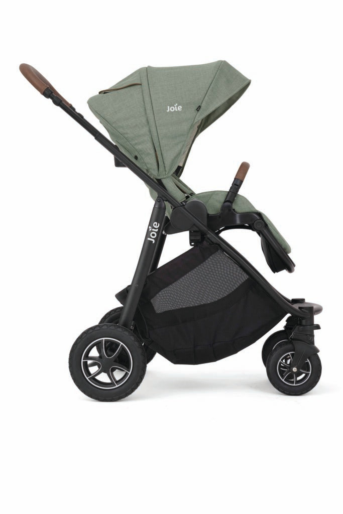 Imagem principal do sistema Joie DUO Versatrax com a alcofa Ramble XL montada, mostrando o carrinho em cor escura com detalhes em pele sintética no guiador.