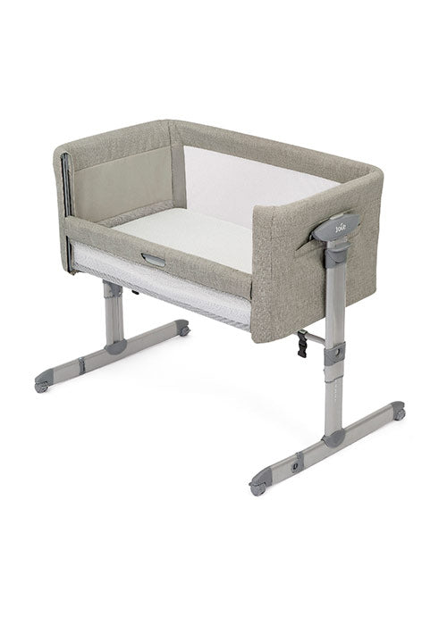 Detalhe do sistema de fecho e das rodas com travão no berço Joie Roomie glide, ilustrando a mobilidade e segurança.