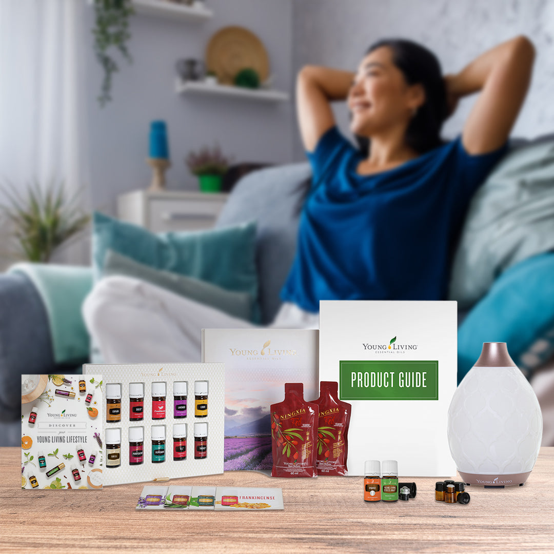 Kit inicial Young Living com difusor Desert Mist, óleos essenciais, suplementos e guias informativos sobre um fundo de madeira.