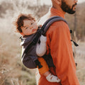 Imagem de um pai a usar a Mochila Neobulle com o bebé nas costas durante uma caminhada na natureza.