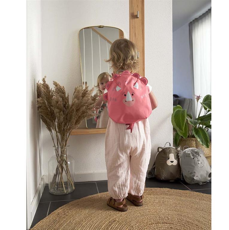 Criança pequena (cerca de 3 anos) a usar a mochila Lassig Dino, demonstrando o tamanho perfeito para uso pré-escolar.