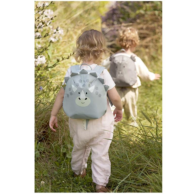 Criança a usar a mochila infantil Lässig Dino num passeio ao ar livre.