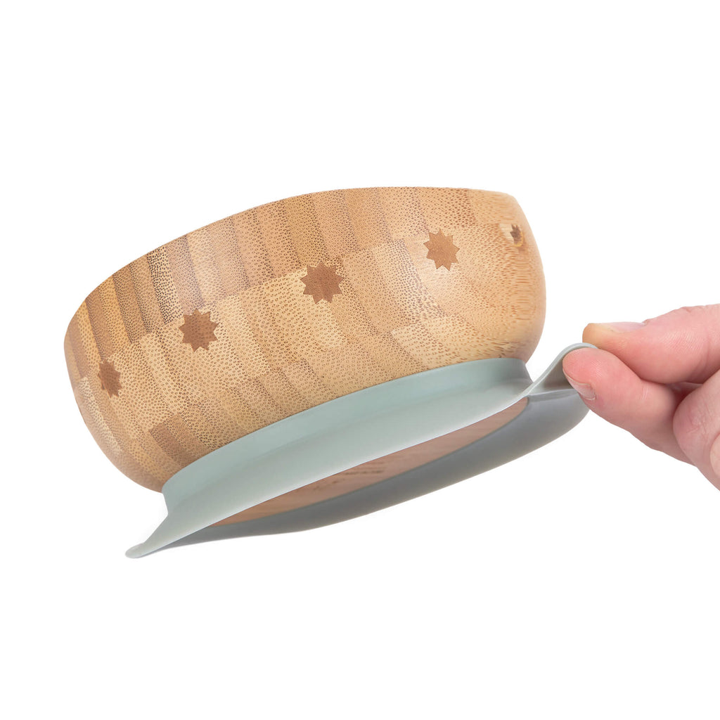 Mão a segurar taça de bambu Lässig com ventosa para demonstrar estabilidade.