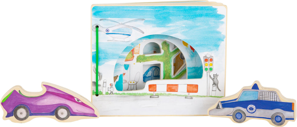 Detalhe da página do livro mostrando um helicóptero, semáforo e um gato.  Veículos de madeira (carro de polícia e carro roxo) ao lado.