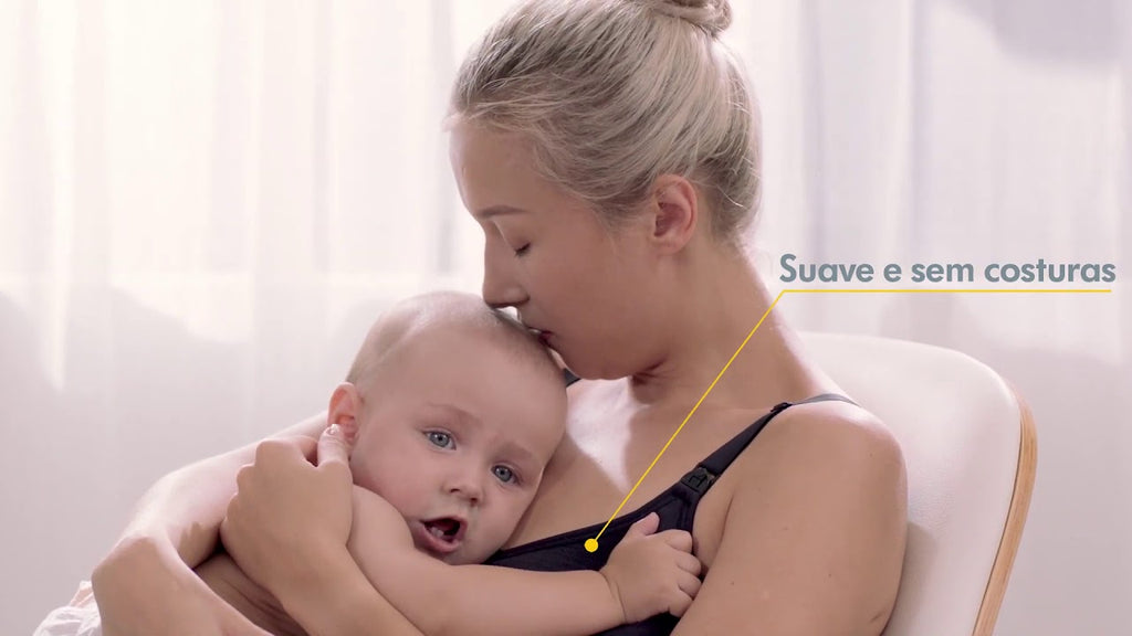 Mãe a amamentar o seu bebé, usando um sutiã Medela Comfy (cor escura), destacando o conforto e a praticidade.