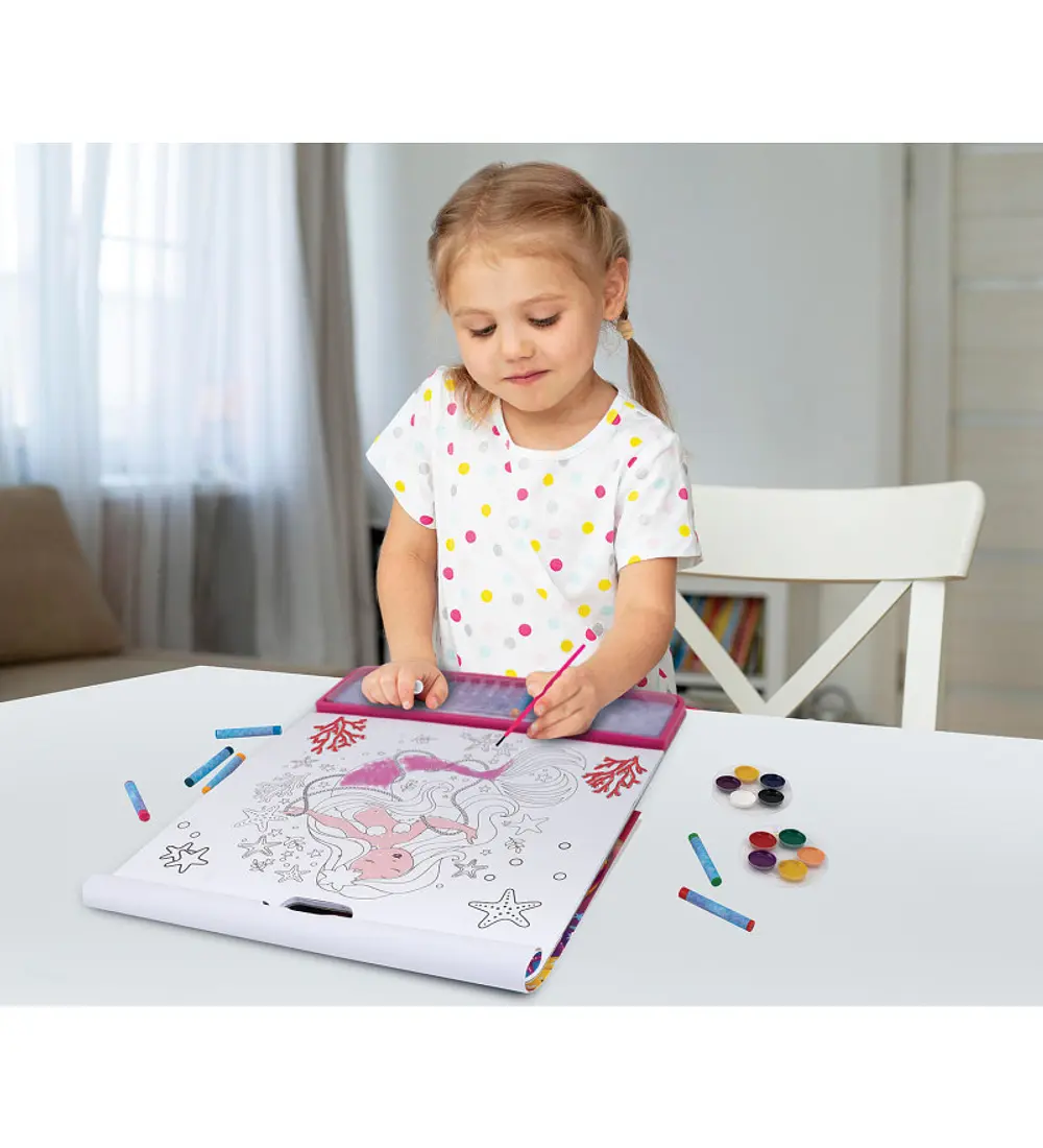 Uma menina concentrada a colorir uma sereia no bloco gigante, mostrando a imersão na atividade criativa.